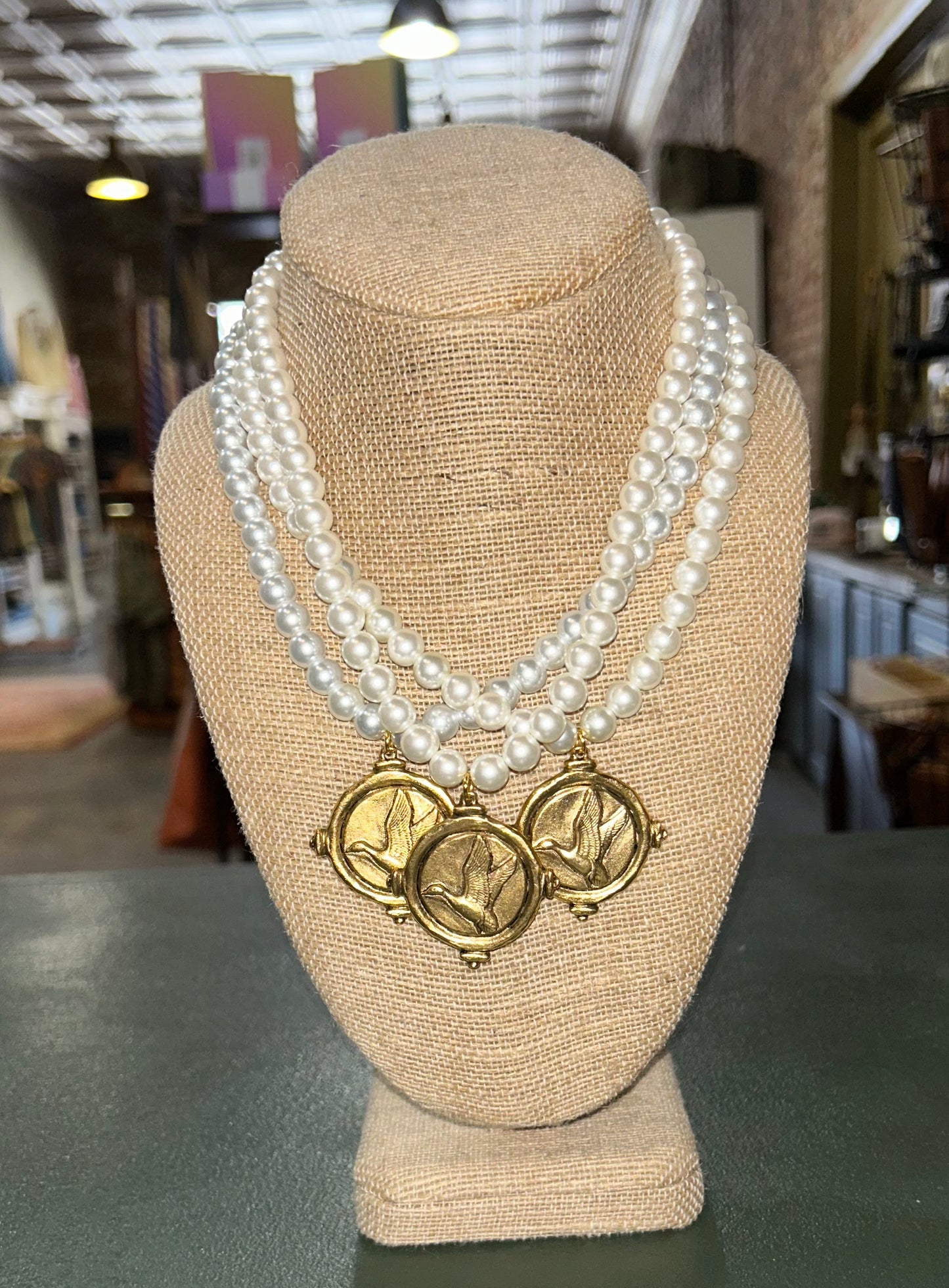 Brushed Gold Flying Duck Pendant on Pearl Necklace